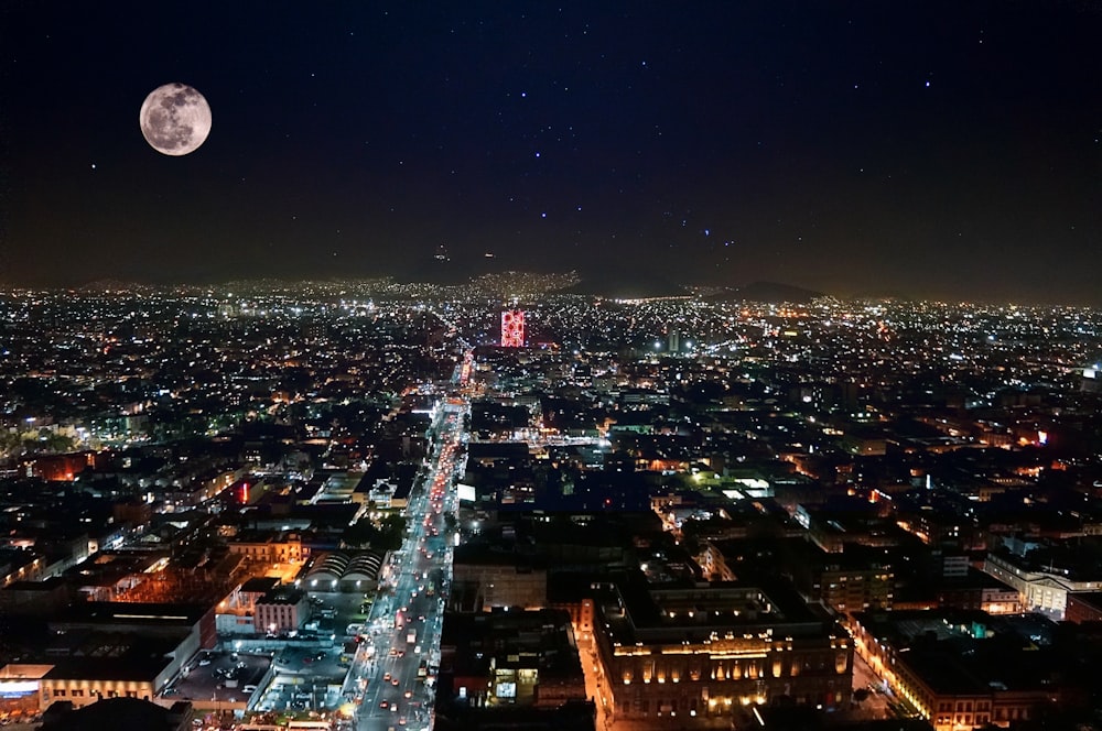 full moon above lighted building during night