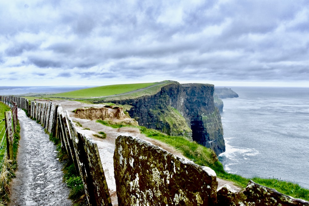 road with fences near the edge of a mountain during day