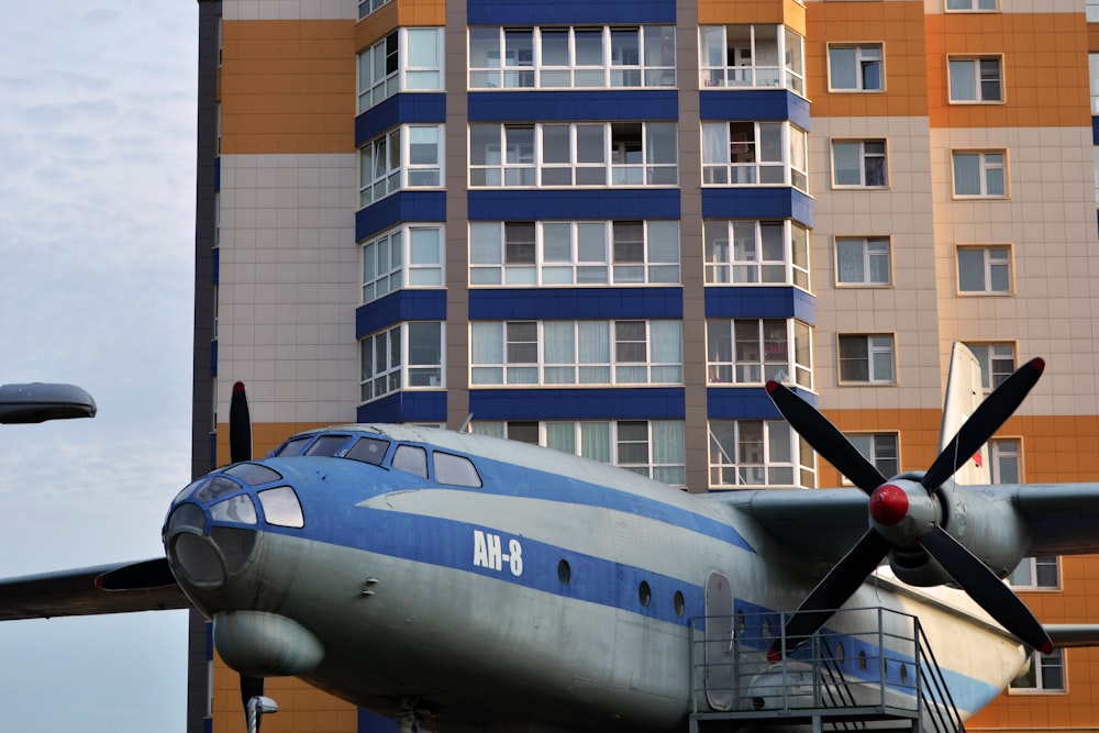 grey and blue plane beside building