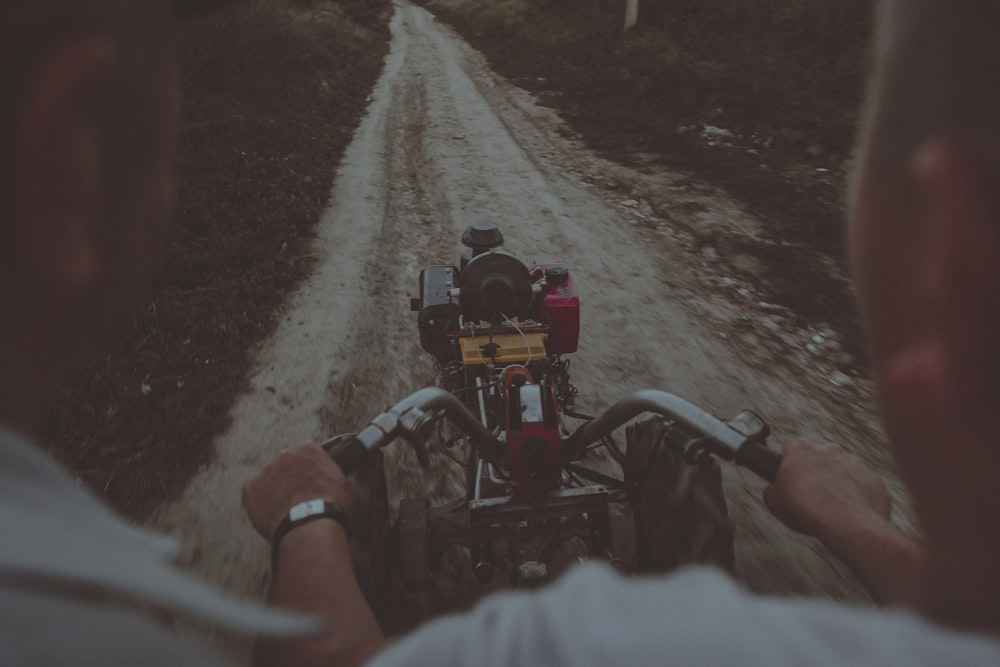 a man riding a motorcycle down a dirt road