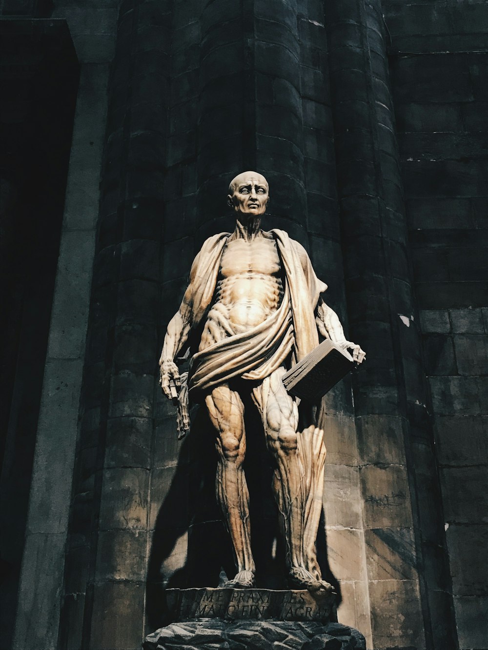 a statue of a man with a book in his hand