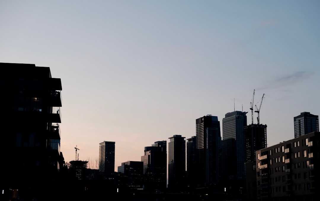 a city skyline with tall buildings and cranes,