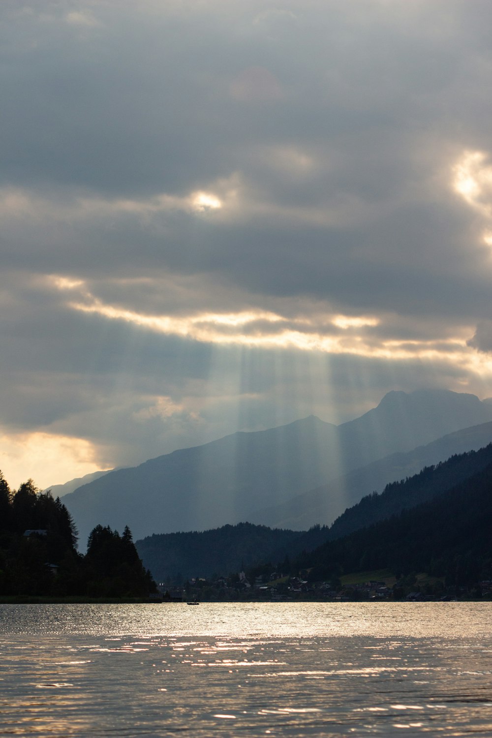 the sun is shining through the clouds over the water