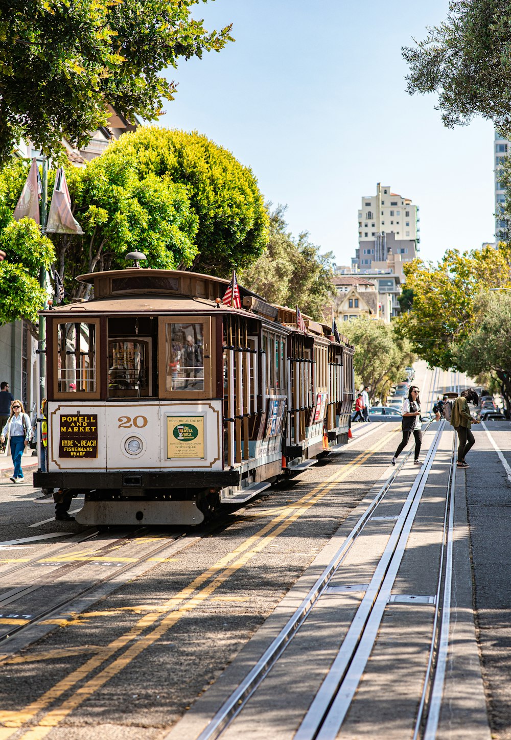 brown and white train traveling on city road