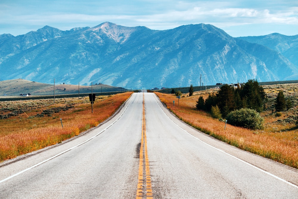 gray concrete road in front of mountain range