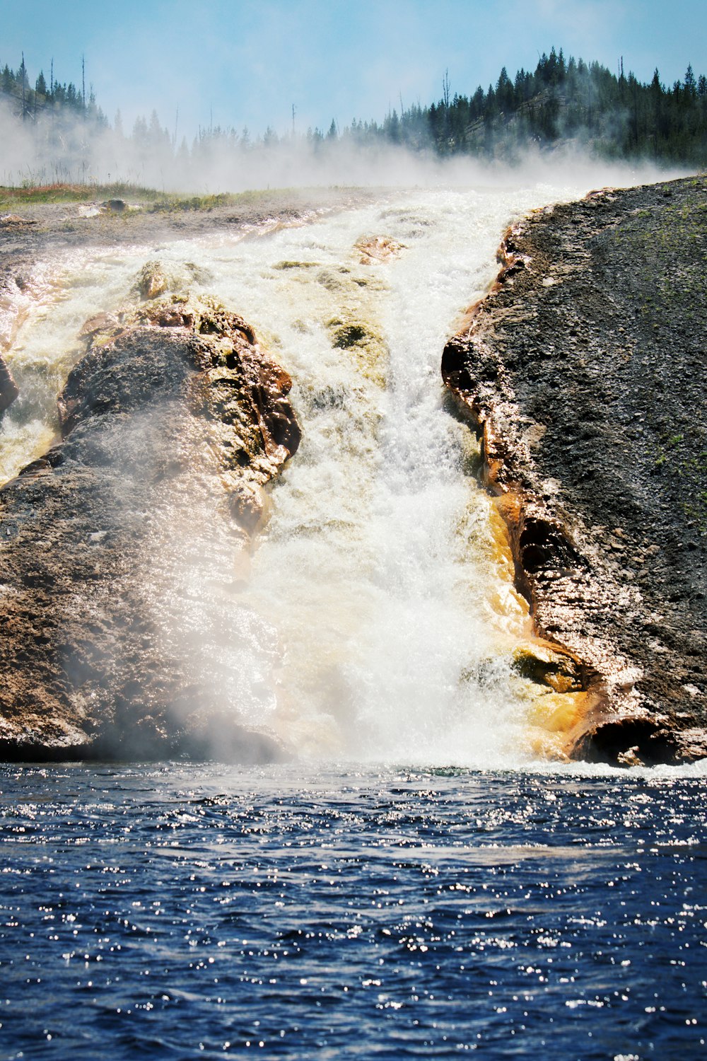 a large waterfall with steam coming out of it