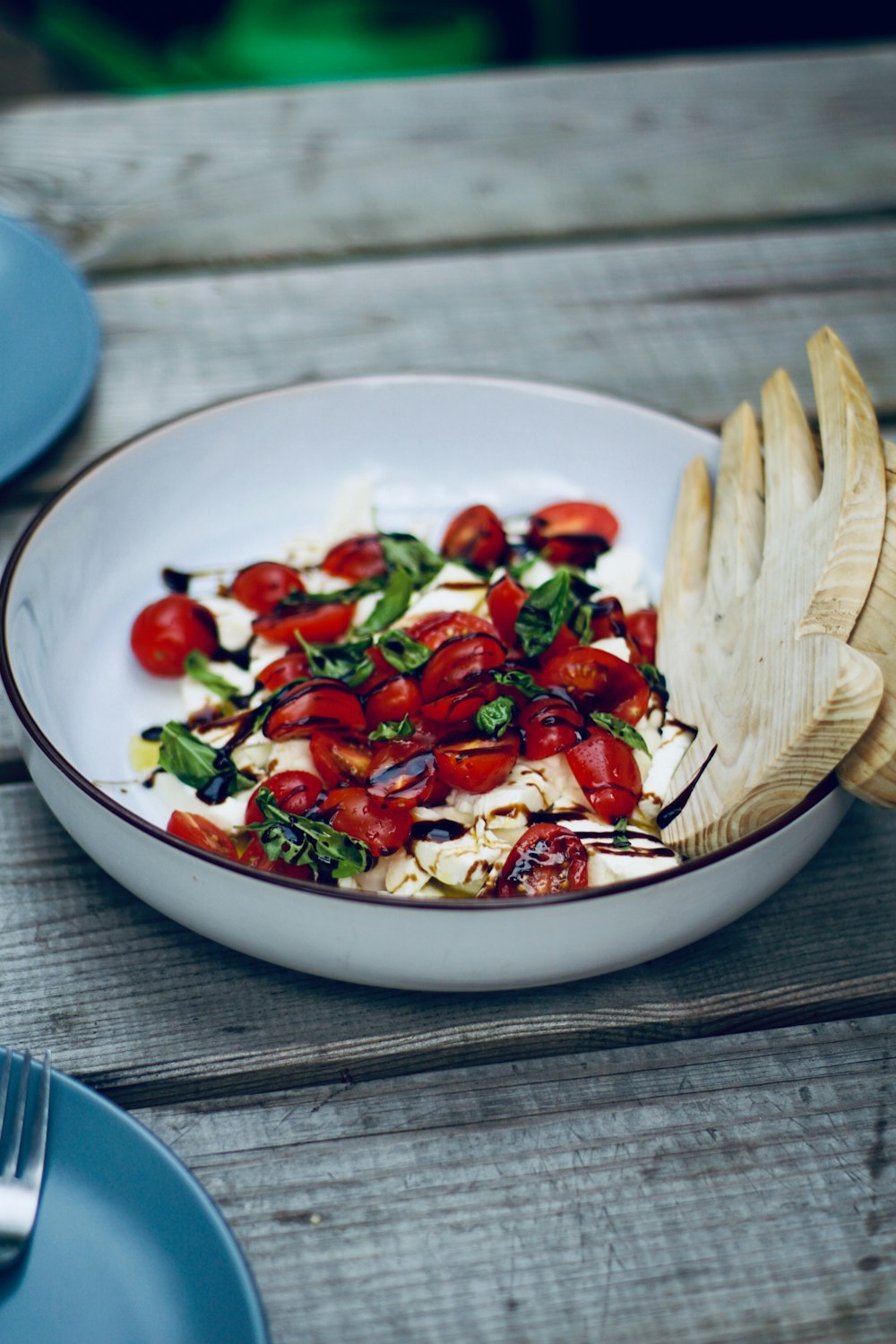 a white bowl filled with lots of food on top of a wooden table