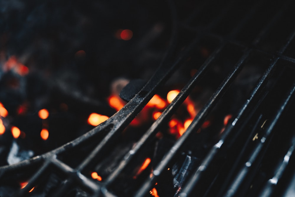 a close up of a grill with flames in the background