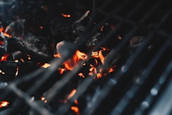 Close-up of glowing charcoal briquettes burning steadily in a commercial grill.