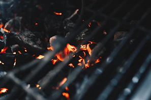 Close-up of glowing coconut shell charcoal briquettes burning bright in a BBQ grill