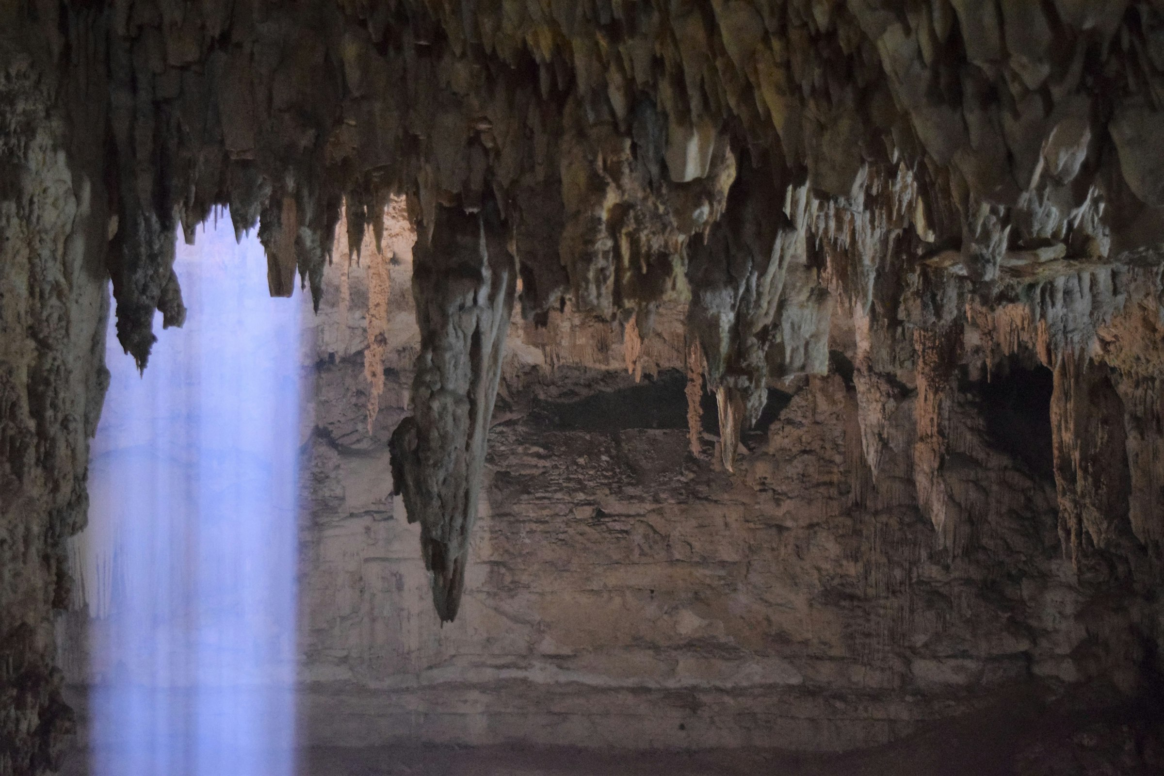 Stalactites hanging from the ceiling of a closed cenote. 