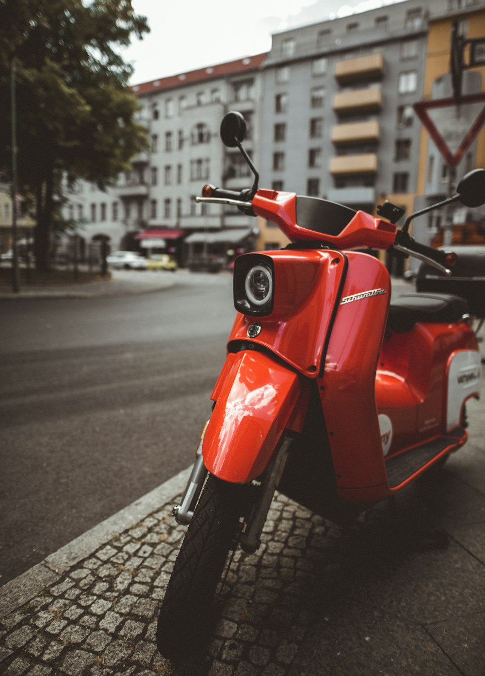 red motor scooter parked near road