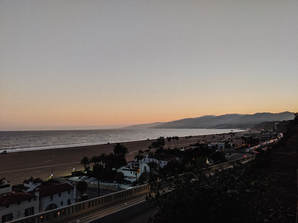 a view of a beach and a city at sunset