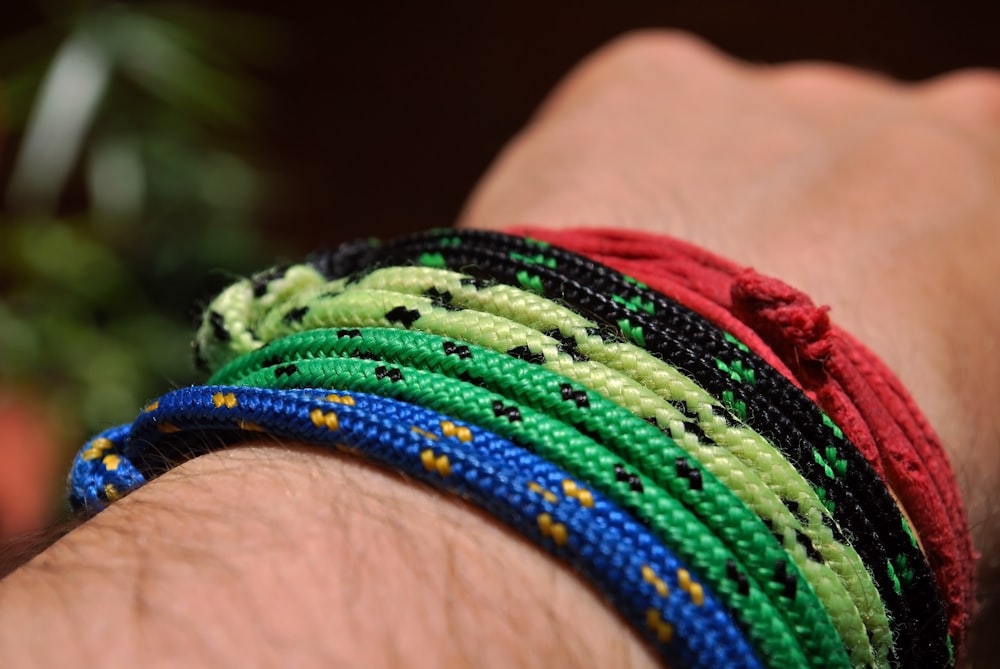 person wearing assorted color cord bracelets