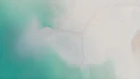 Aerial view of turquoise waters meeting white sandy shores.