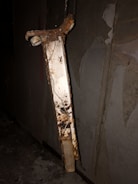 A metal fixture being delicately stripped to reveal its aged patina.