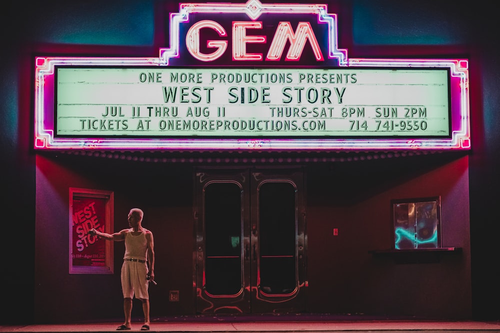 man standing in front GEM movie house
