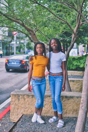 two girls standing near tree