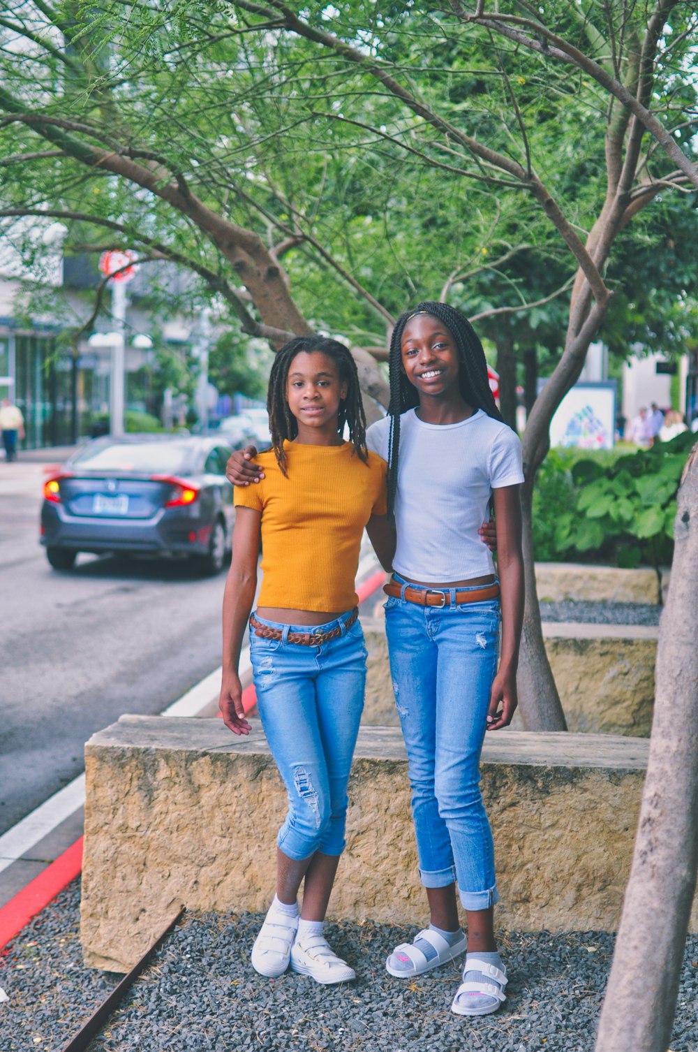 two girls standing near tree