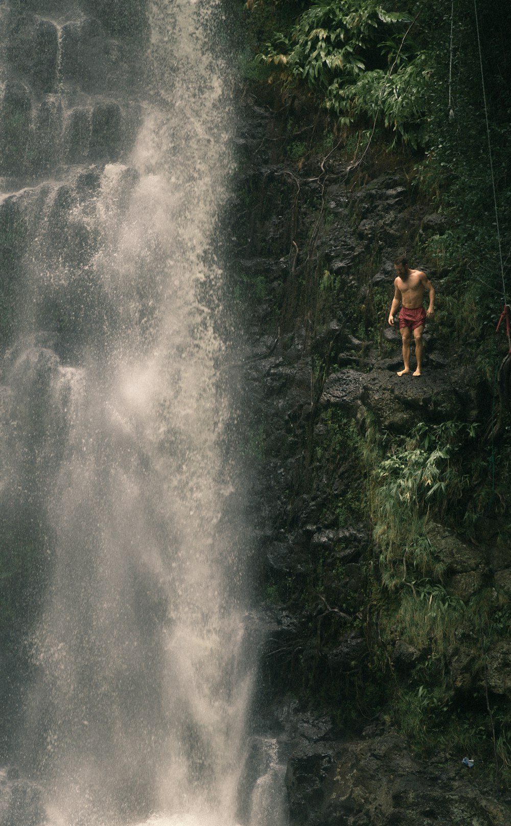 a man standing in front of a waterfall