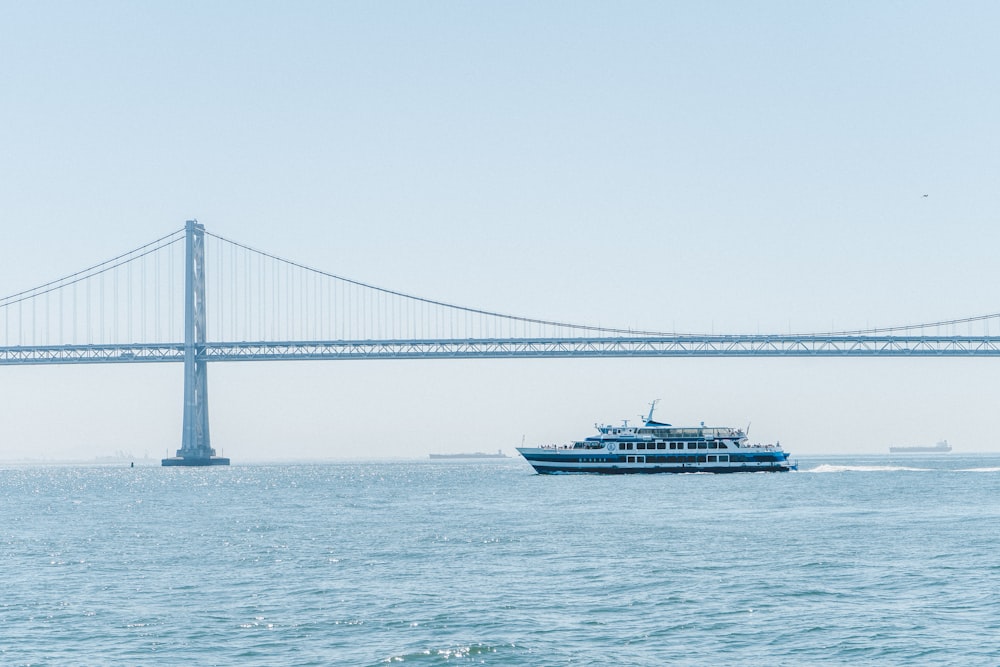 ship in sea with steel bridge in background