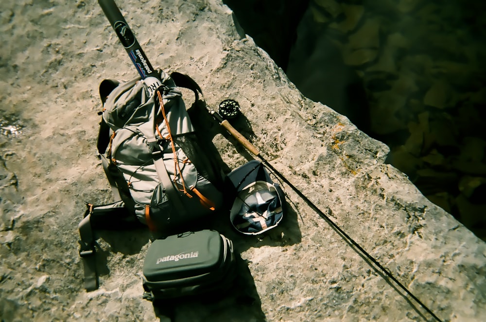backpack and fishing rod on rock
