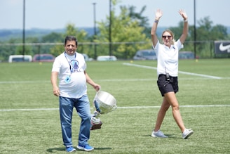 Winners celebrating with trophies and cheers on a sunny day.