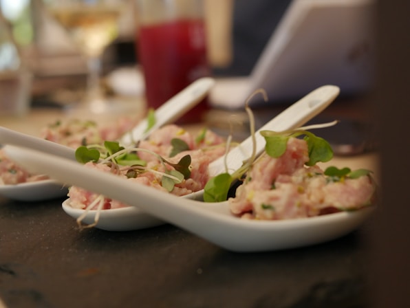 appetizer on white Chinese spoons on table