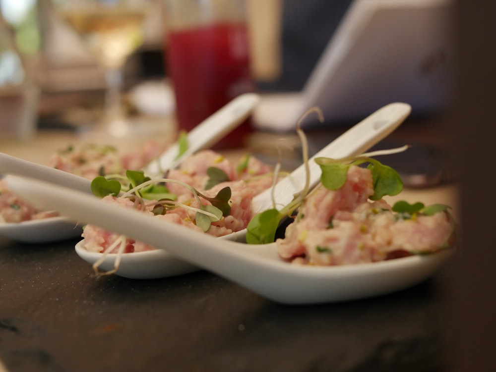 appetizer on white Chinese spoons on table