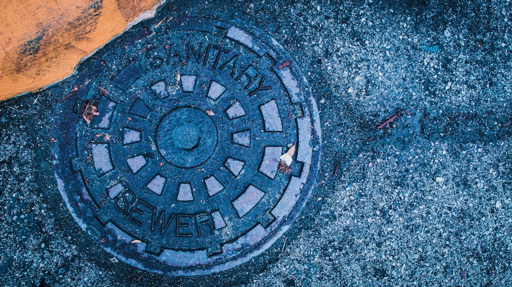 a manhole cover sitting on the side of a road