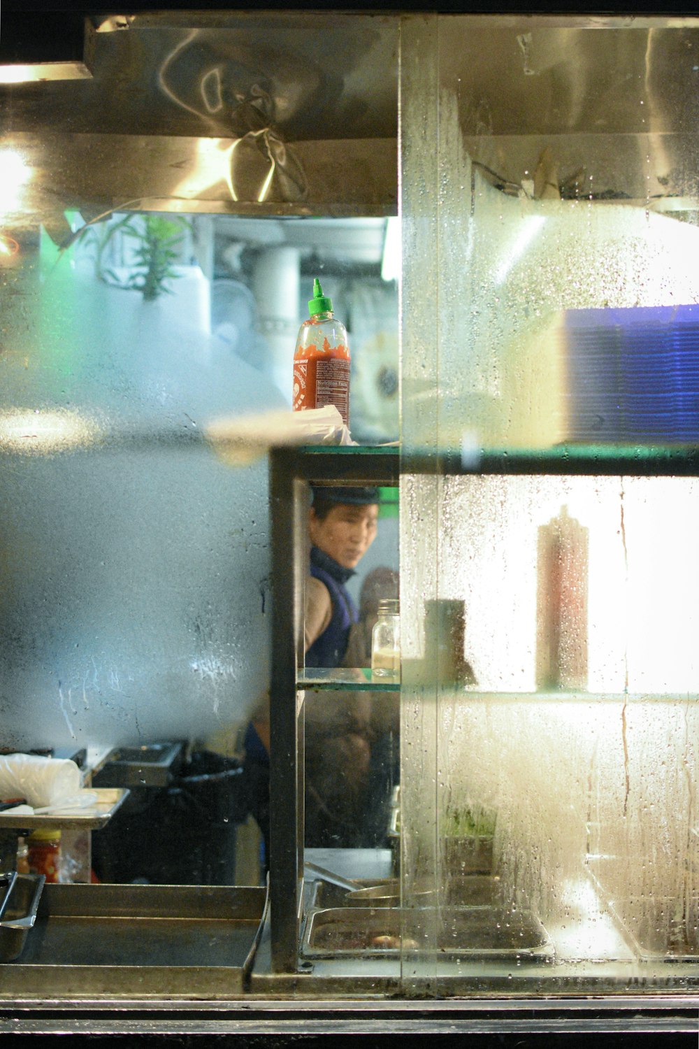 man inside kitchen view from glass moist window