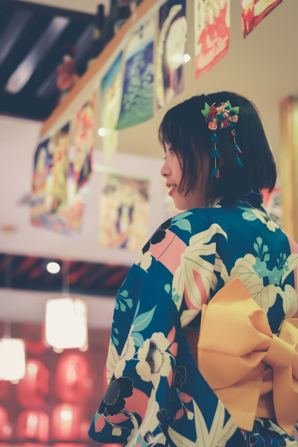 a woman wearing a colorful kimono and a yellow bow