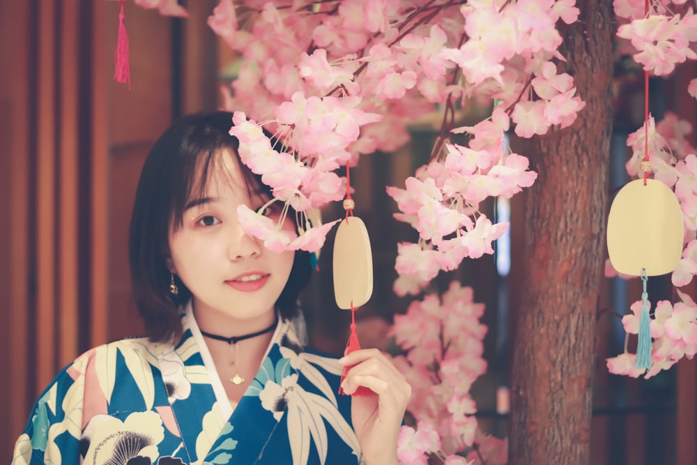 woman standing under pink flowered tree