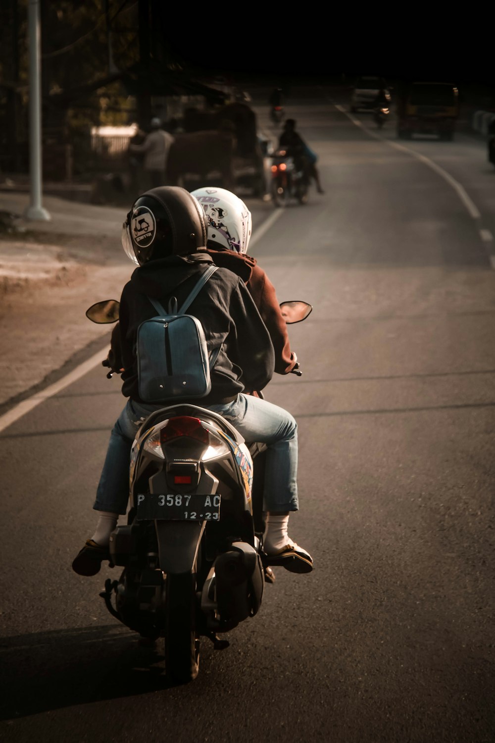 two persons ride motorcycle at the street