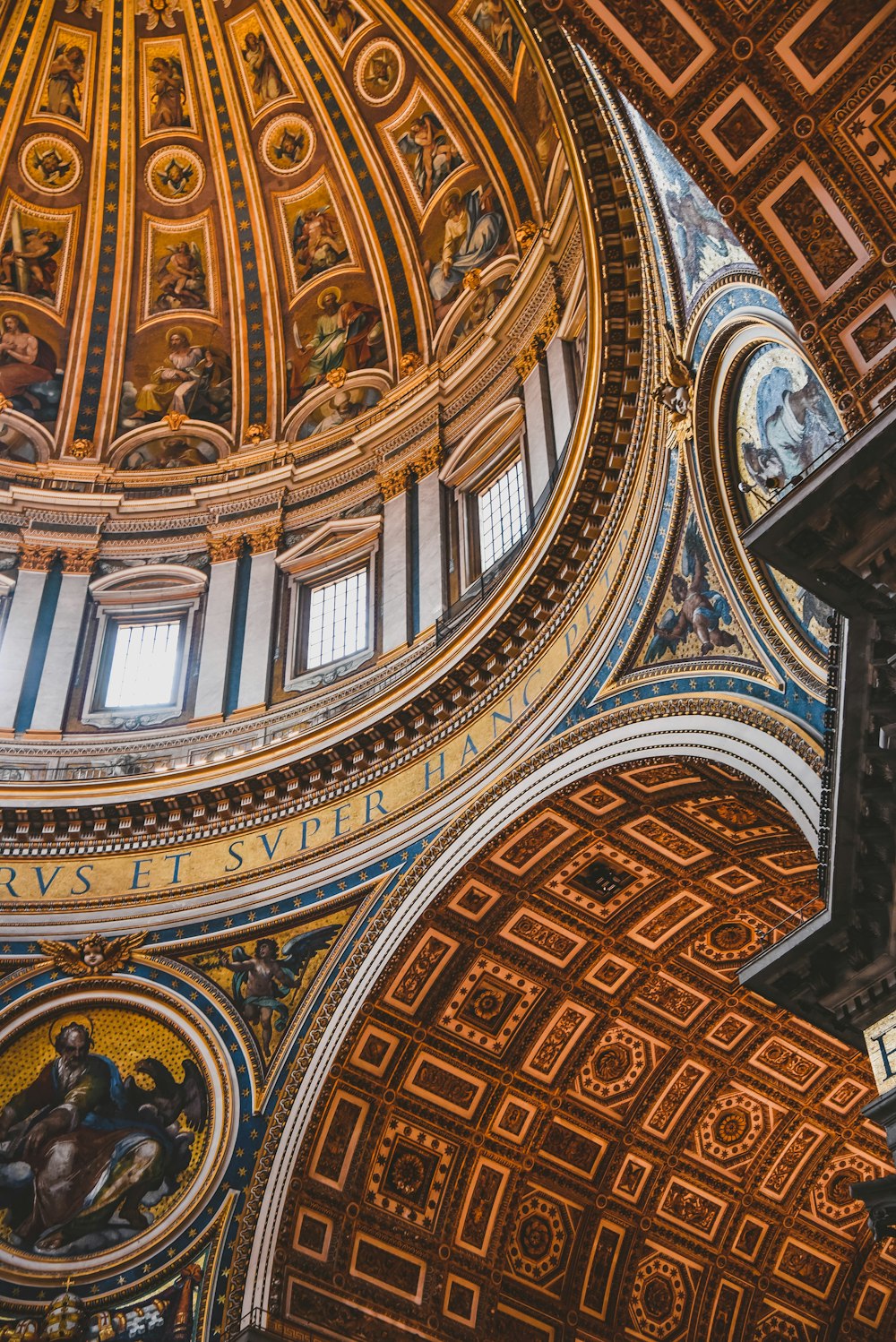 the ceiling of a building with a clock and paintings on it