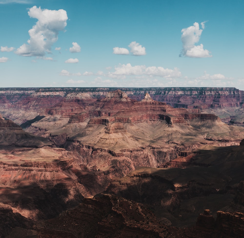 brown rock cliff under white clouds