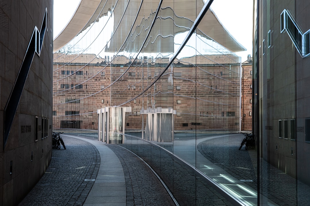 reflection of narrow pathway on mirror walled building