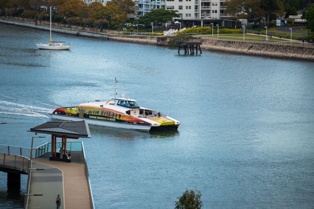 white and yellow yacht on body of water