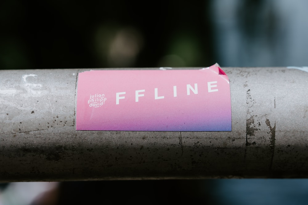 a pink sticker is on a metal pipe