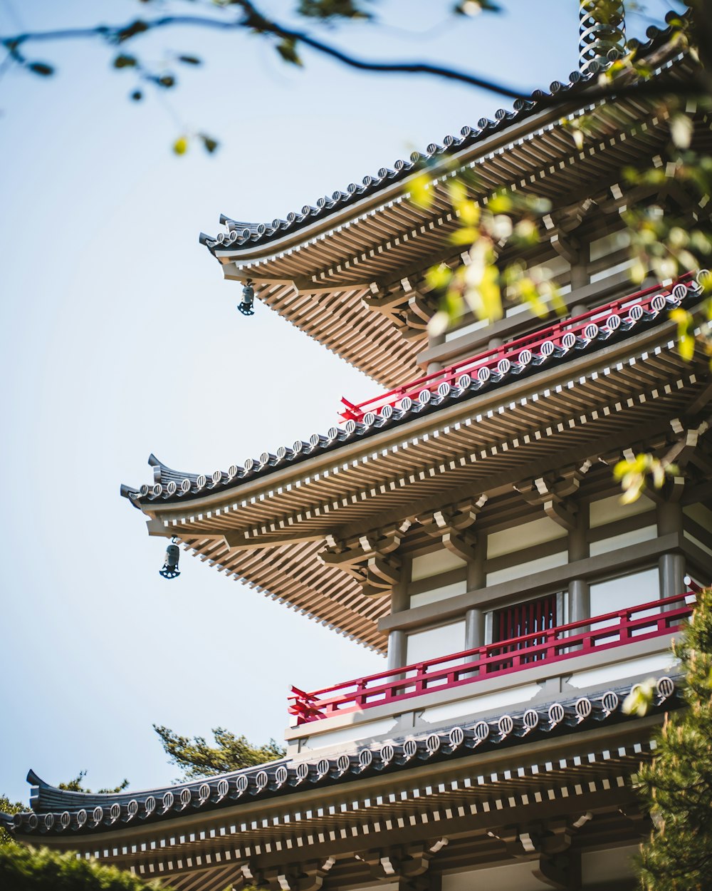 a tall building with a red roof and a sky background