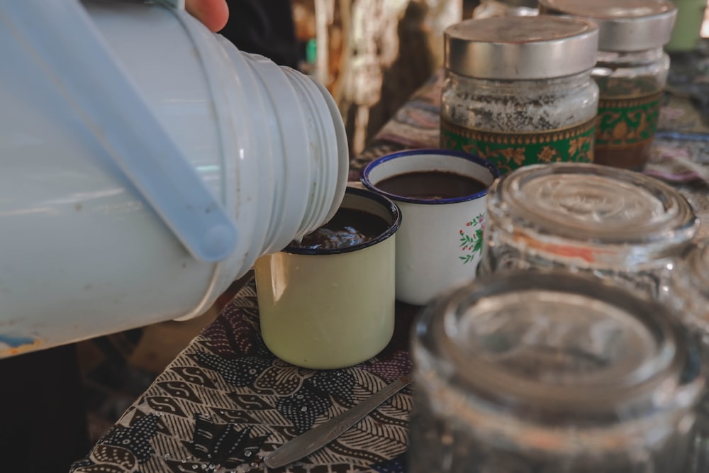 Eine Person gießt Kaffee in eine Tasse