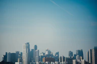 City skyline of Kuwait with modern buildings under a clear blue sky.