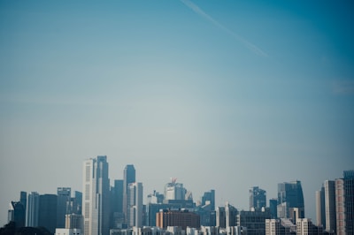 Modern city skyline with residential and commercial buildings under clear sky.