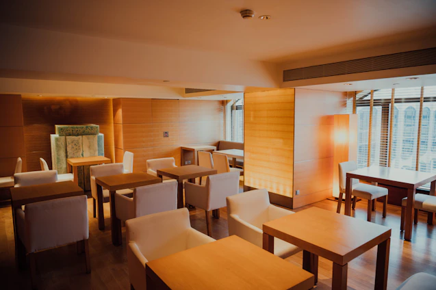 A cozy Scandinavian-style restaurant interior with warm lighting, featuring a team planning content around a wooden table.
