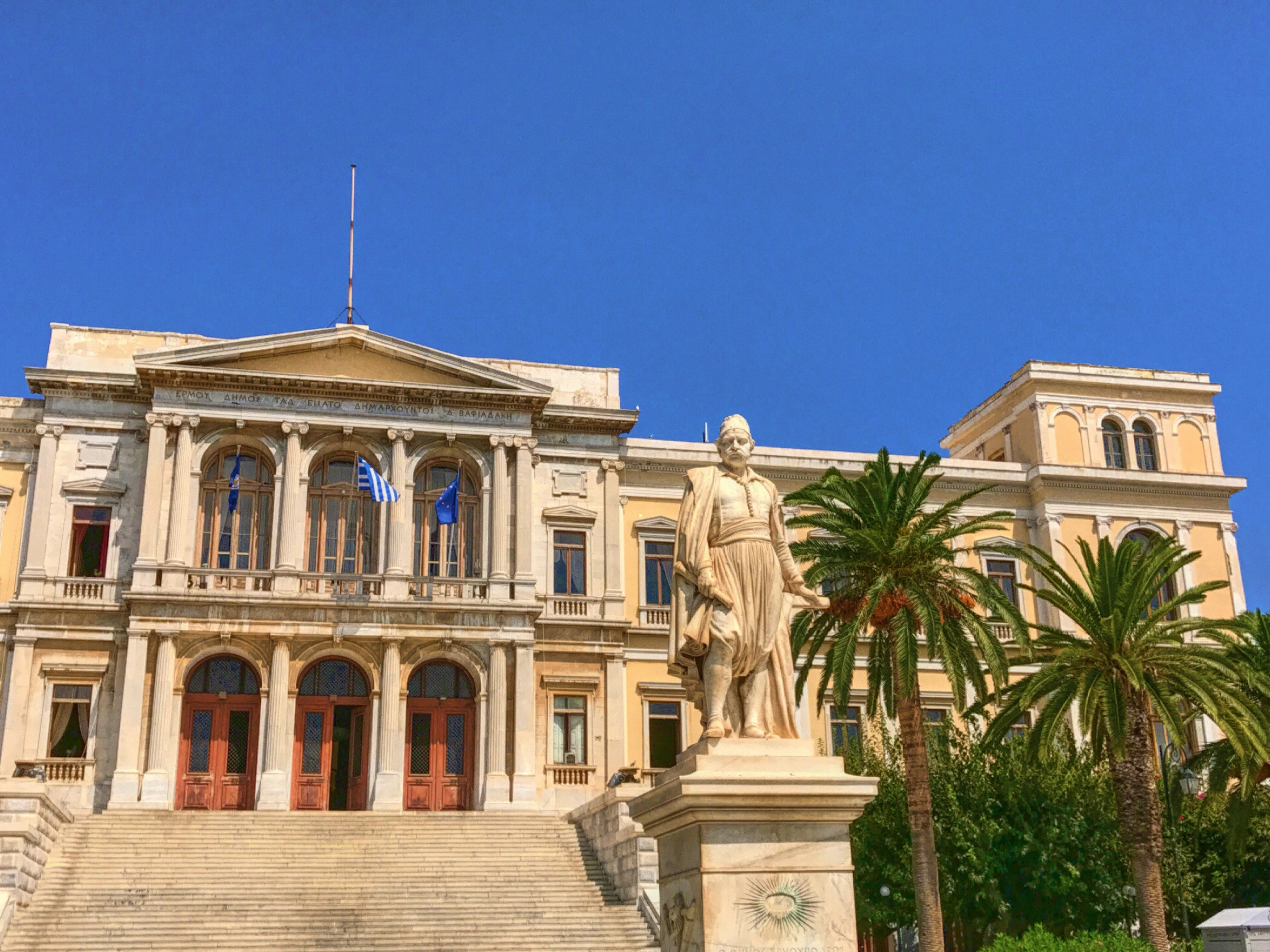 statue of a man in front of a concrete building
