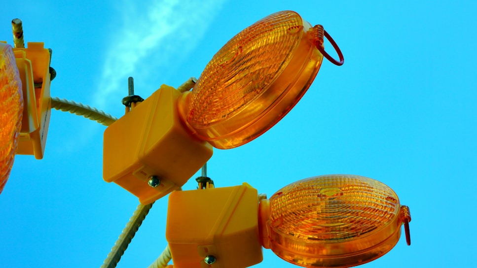 Solar lighting tower glowing brightly on a nighttime construction site with navy blue battery base visible.
