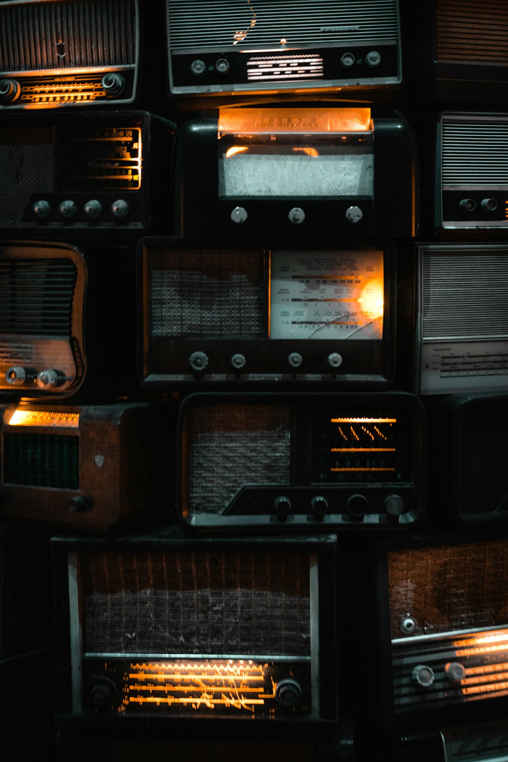 um monte de rádios antigos são empilhados uns sobre os outros