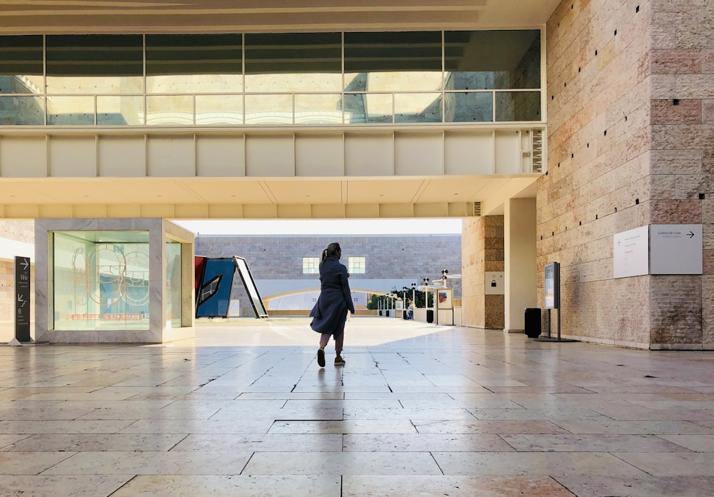 walking person wearing robe under bridge