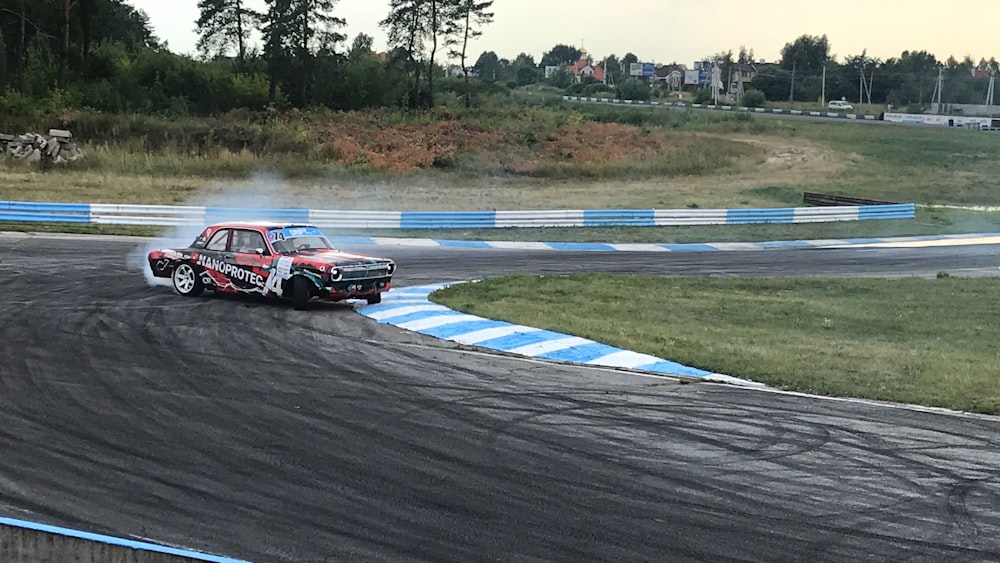 carro de corrida vermelho e preto na pista