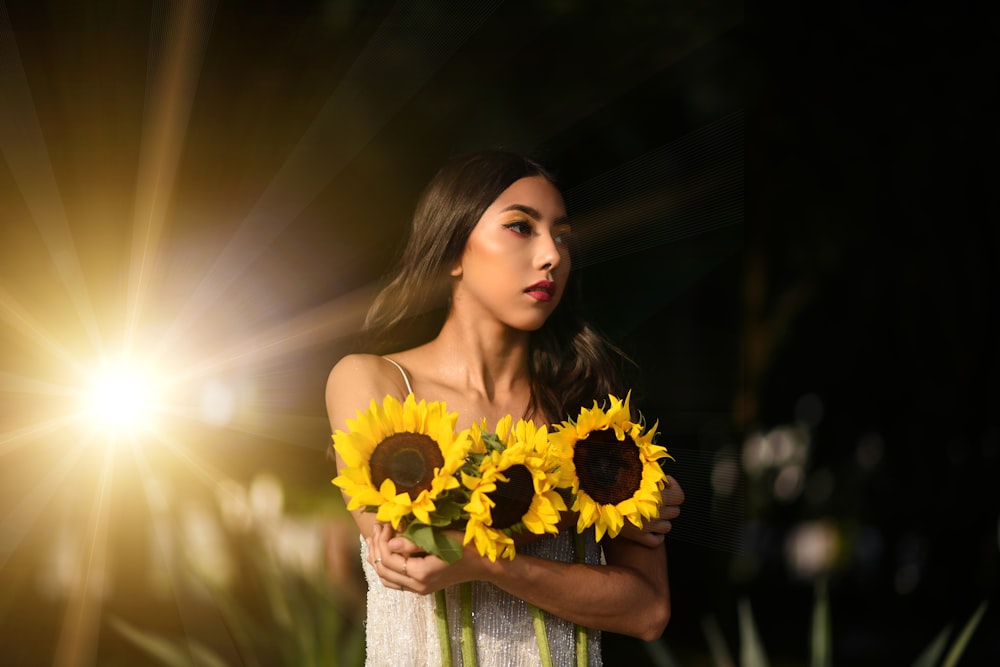 woman standing while carrying sunflowers